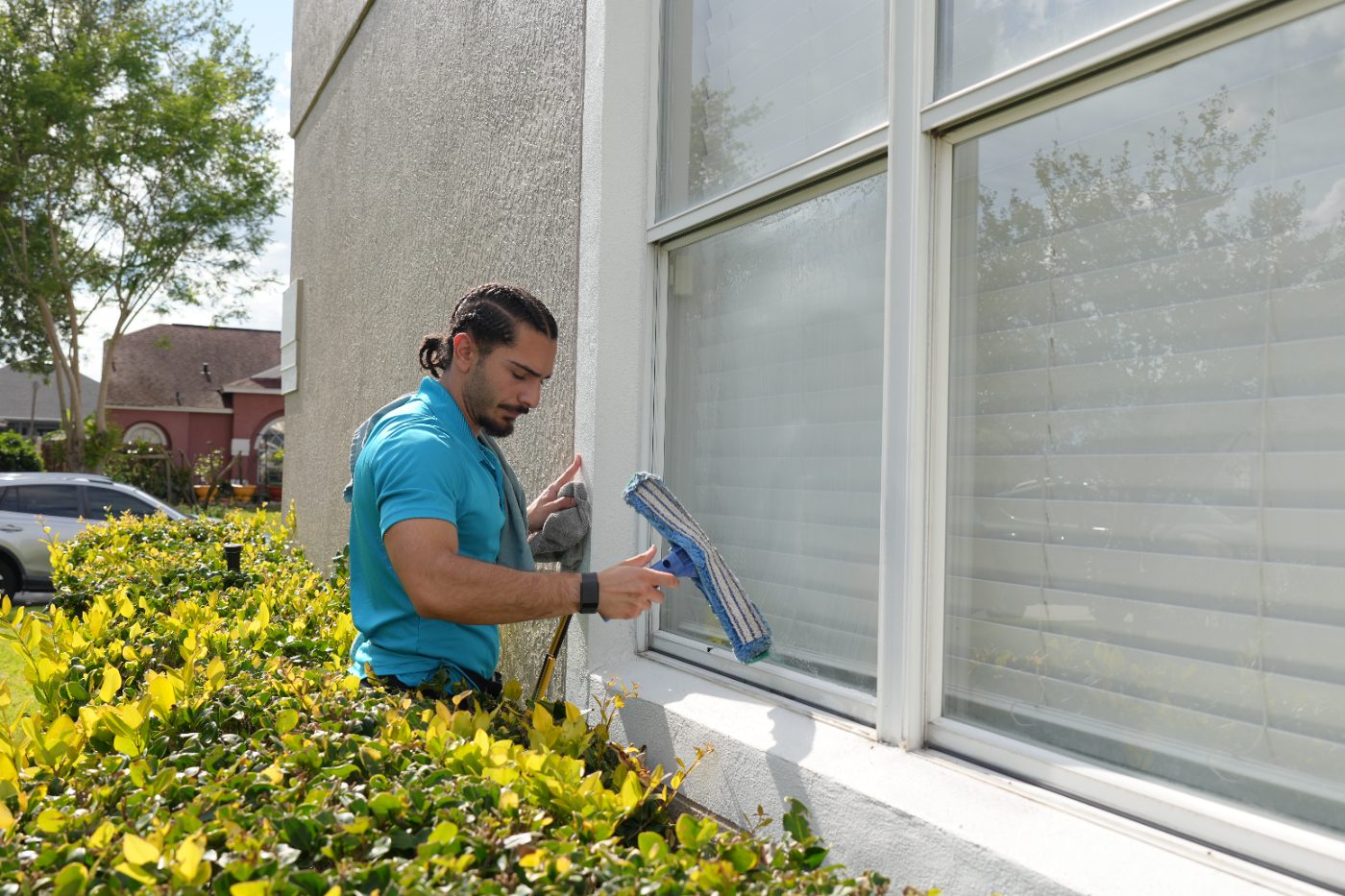 Gloved hand cleaning a window with a squeegee